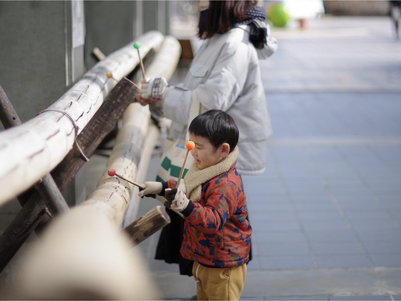 バチで遊ぶ子ども